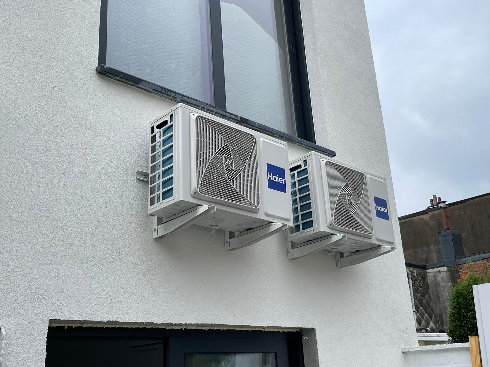 Dubbele Haier buitenunits tegen een witte gevel